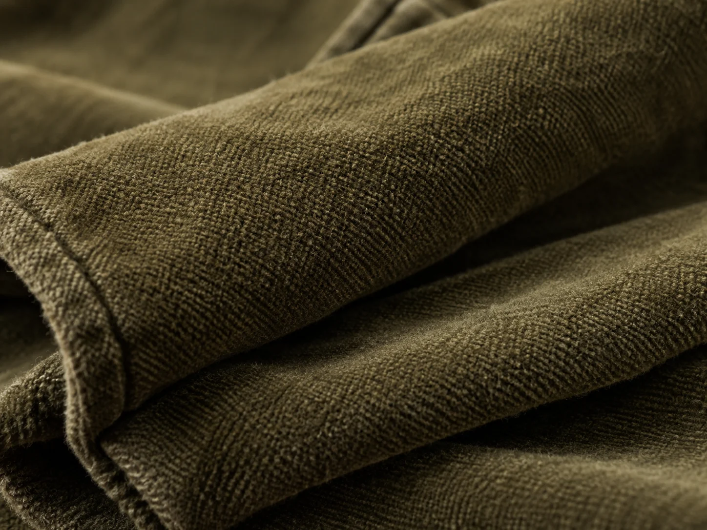 Close-up of olive moleskin fabric showing its dense brushed cotton texture