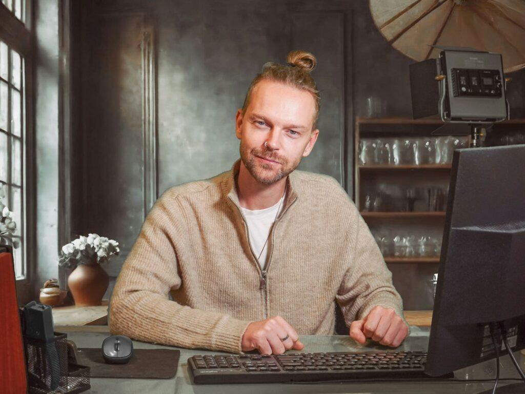 Man in knitwear working at a laptop
